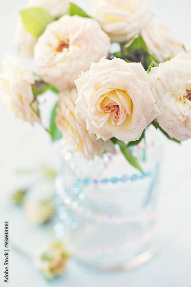 Obraz premium Beautiful fresh roses in a vase on a table . light background .