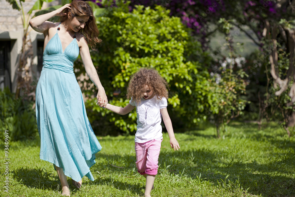 Mother and daughter are enjoying on grass at park Mother and daughter are enjoying on grass at park