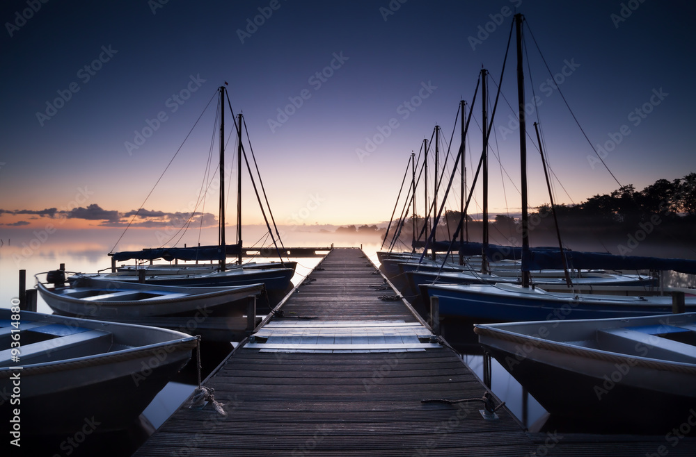 Fototapeta premium pier and yacht on lake at sunrise