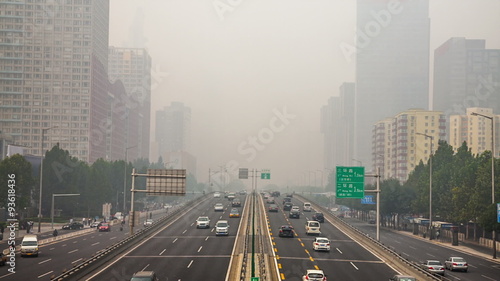 China's capital city of Beijing street traffic of automobiles. Foggy day, smog, air pollution.