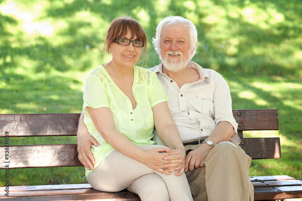 Senior couple sitting on a park bench Senior couple sitting on a park bench