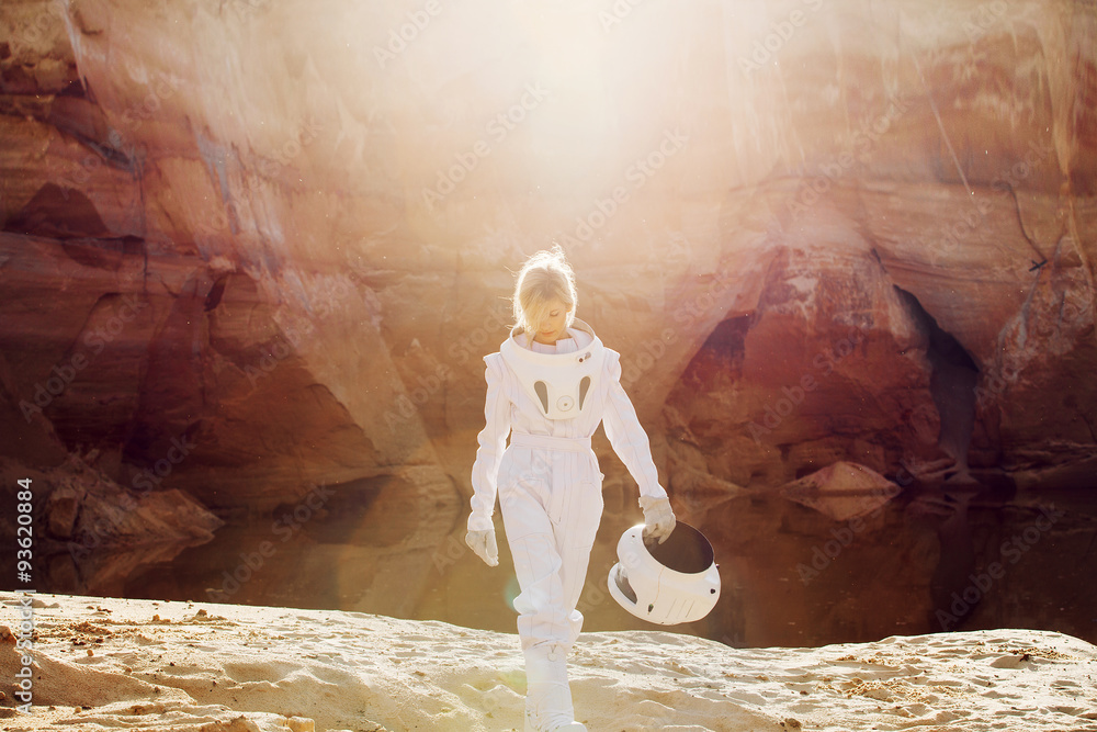 Naklejka premium futuristic astronaut without a helmet in rays of another sun