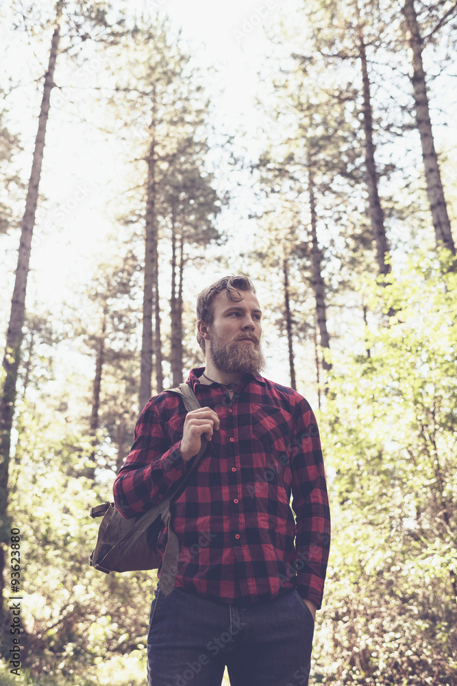 Low angle view of hiker with beard in forest. Low angle view of hiker with beard in forest.