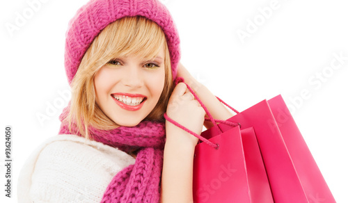 woman in pink hat and scarf with shopping bags