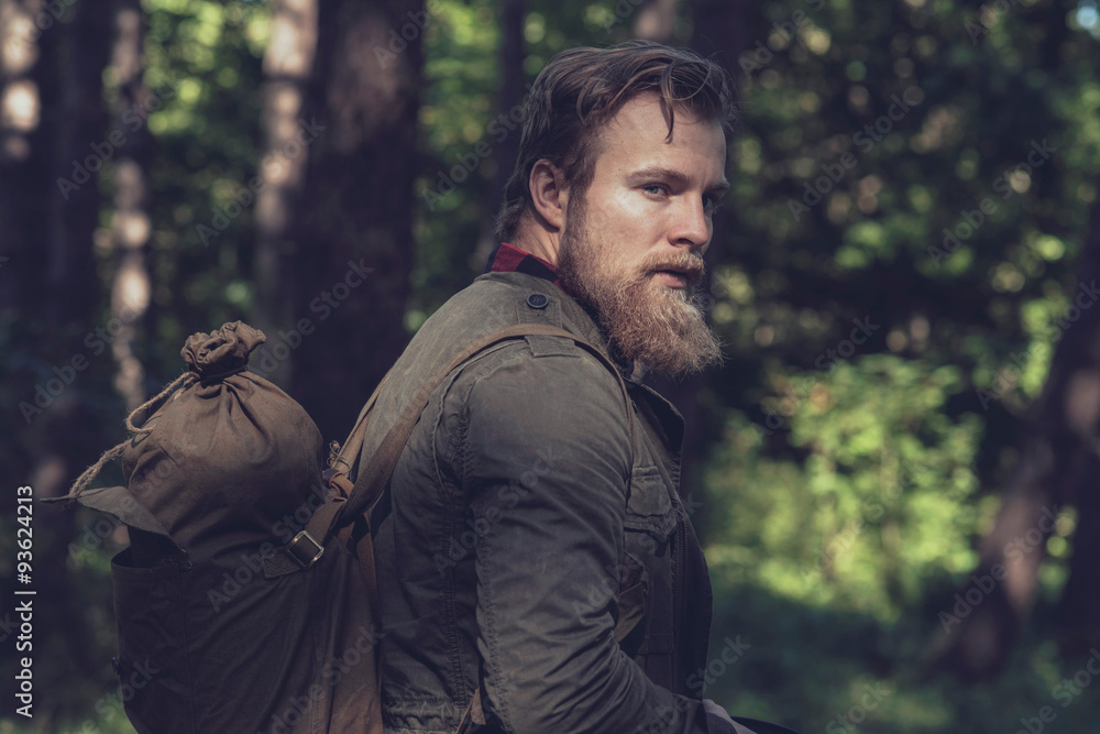 Side view of backpacker with beard in forest. Side view of backpacker with beard in forest.