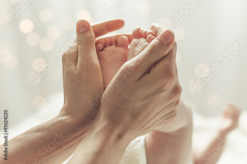 Mother touching feet of newborn