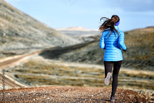 Woman winter and autumn running in down jacket