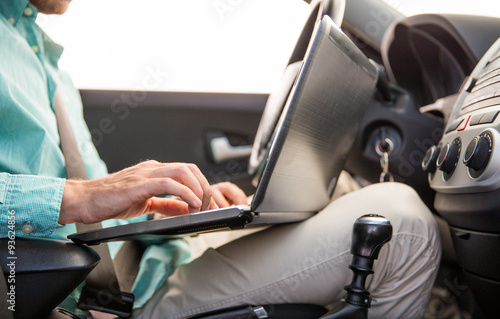close up of young man with laptop driving car © Syda Productions