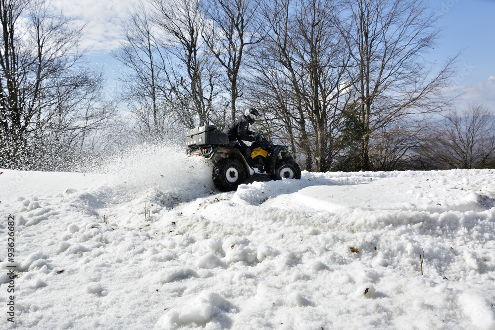man driving a quad bike in the winter field man driving a quad bike in the winter field