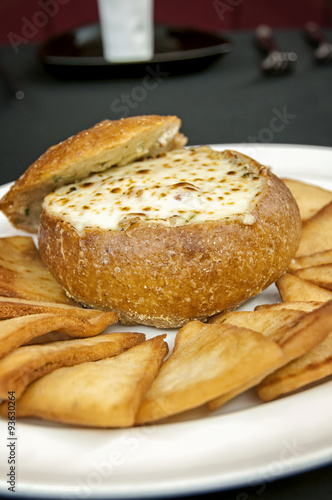 cheese dip appetizer with toast points at a gourmet restaurant in a bread bowl
