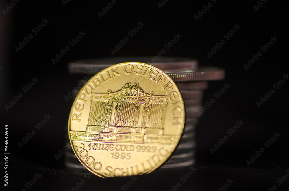 Dramatic Austrian Gold Coin leans against Silver Coins Dramatic Austrian Gold Coin leans against Silver Coins
