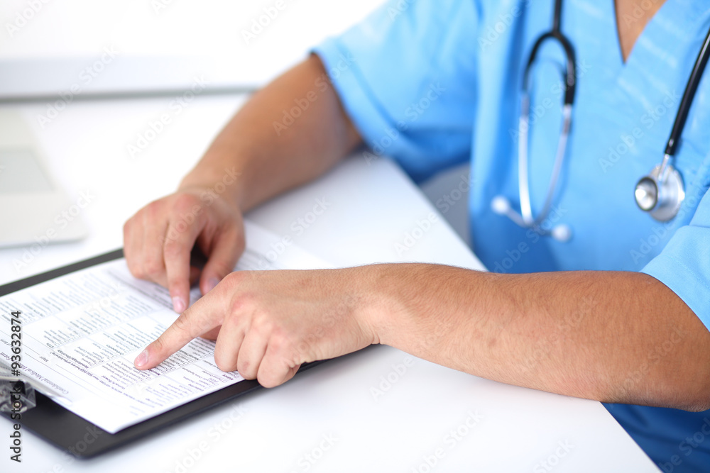 Portrait of unknown male surgeon doctor holding his stethoscope, crossed arms Portrait of unknown male surgeon doctor holding his stethoscope, crossed arms