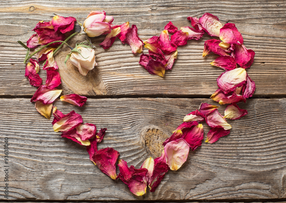 dried rose petals on wooden table dried rose petals on wooden table