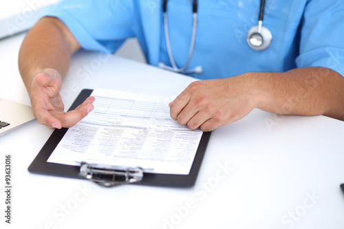 Portrait of unknown male surgeon doctor holding his stethoscope, crossed arms