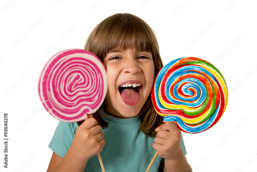beautiful happy female child having fun eating big lollipop spiral candy with  funny face expression
