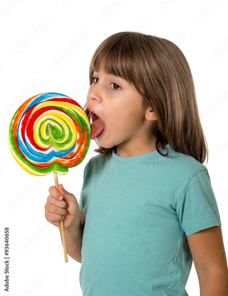 4 or 5 years old child girl eating and licking with tongue big multicolor spiral lollipop candy
