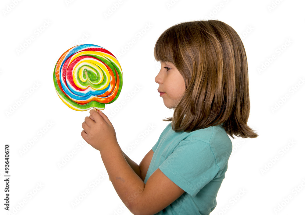 4 or 5 years old child girl eating big multicolor spiral lollipop candy isolated on white background in children love sweet and sugar concept and dental health and care concept