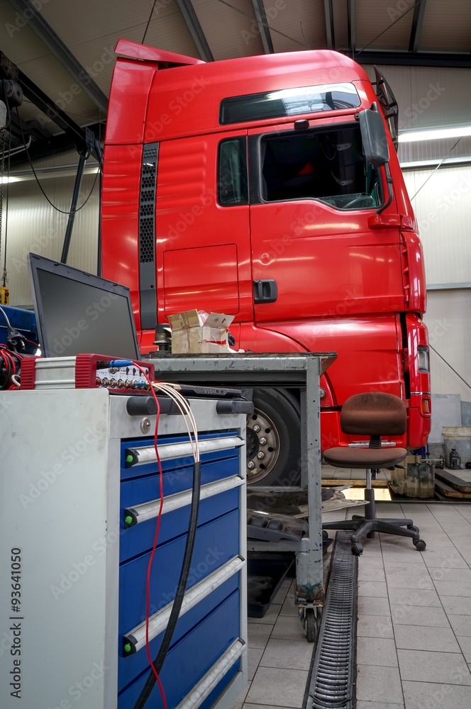 LKW-Werkstatt, rote Zugmaschine mit Fahrzeugdiagnostik LKW-Werkstatt, rote Zugmaschine mit Fahrzeugdiagnostik