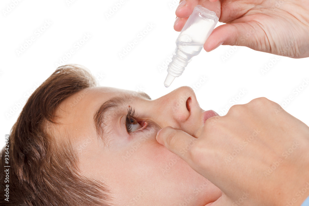 Boy applying eye drop on white background Boy applying eye drop on white background