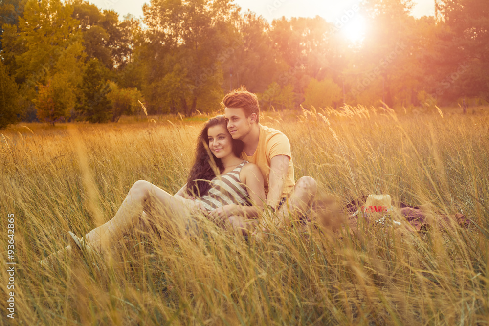 Loving couple lying down on floral field in autumnal park, warm sunny day, enjoying family, romantic date, happiness and love concept. hug and happiness. Loving couple lying down on floral field in autumnal park, warm sunny day, enjoying family, romantic date, happiness and love concept. hug and happiness.