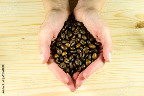 Coffee beans in beautiful hands photo