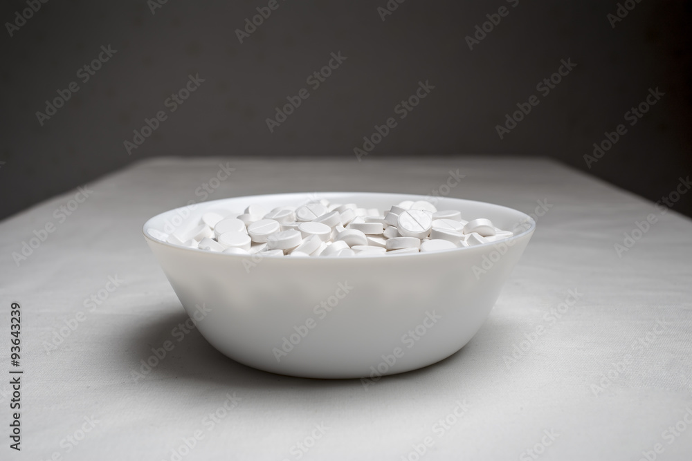 plate filled with medical pills drugs is on the table with a white cloth on a dark background plate filled with medical pills drugs is on the table with a white cloth on a dark background