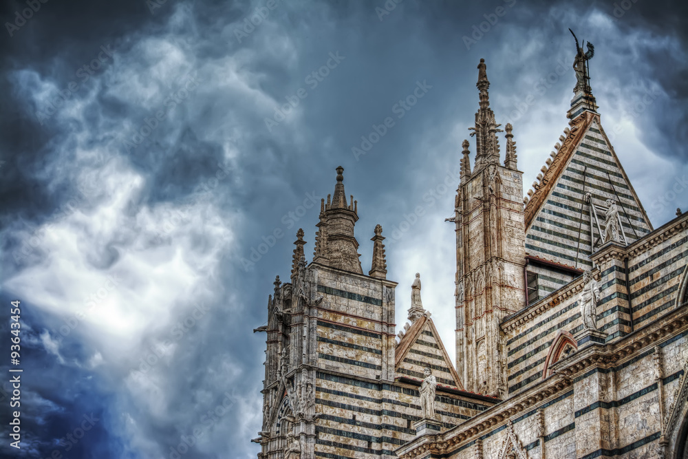 Siena Duomo under a dramatic sky seen from behind Siena Duomo under a dramatic sky seen from behind
