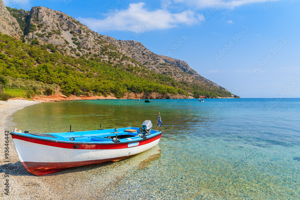 Traditional Greek fishing boat in sea bay on secluded beach, Samos island, Greece