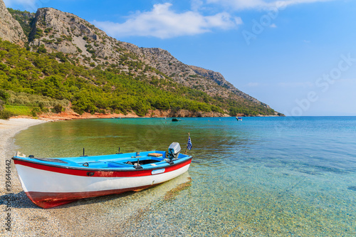 Traditional Greek fishing boat in sea bay on secluded beach, Samos island, Greece