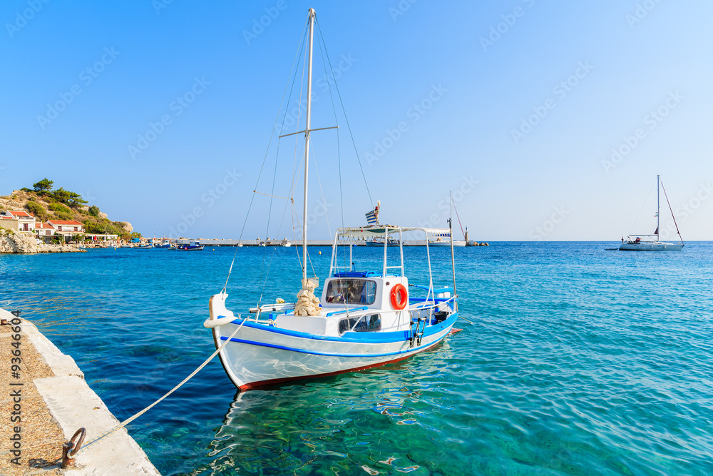 White and blue color Greek fishing boat mooring in Kokkari port, Samos island, Greece