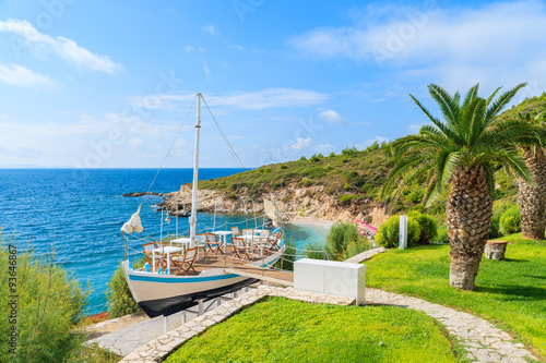 Traditional sailing boat in green garden on coast of Samos island, Greece