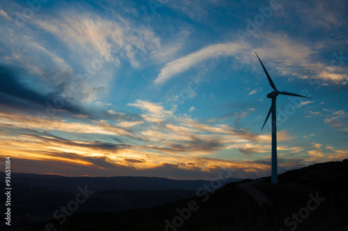 Single Wind Turbine generating electricity on a remote hilltop in Spain. Set agains a sunset sky