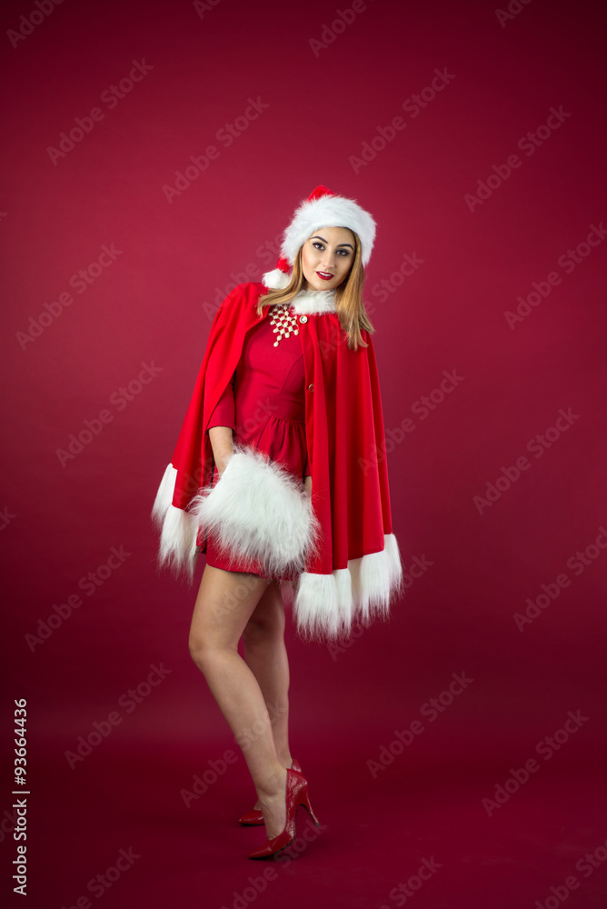 Portrait of beautiful sexy girl wearing Santa Claus clothes on red background Portrait of beautiful sexy girl wearing Santa Claus clothes on red background
