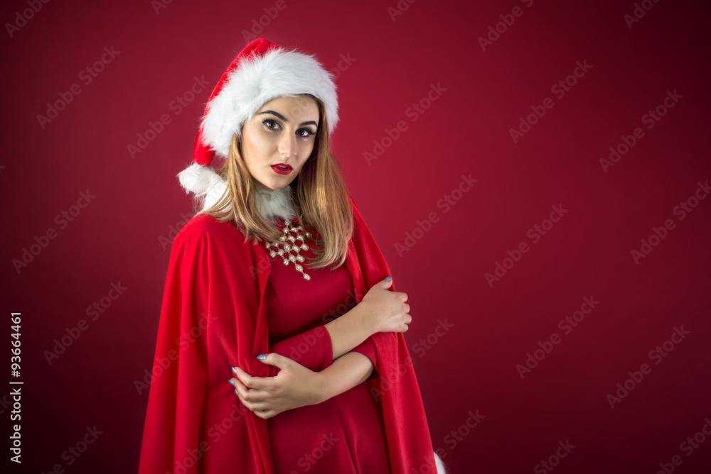 Portrait of beautiful sexy girl wearing Santa Claus clothes on red background Portrait of beautiful sexy girl wearing Santa Claus clothes on red background