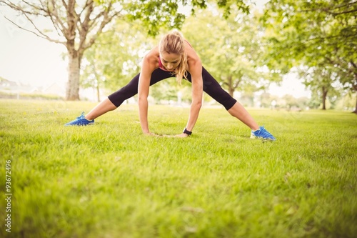 Fit woman exercising with stretching leg 