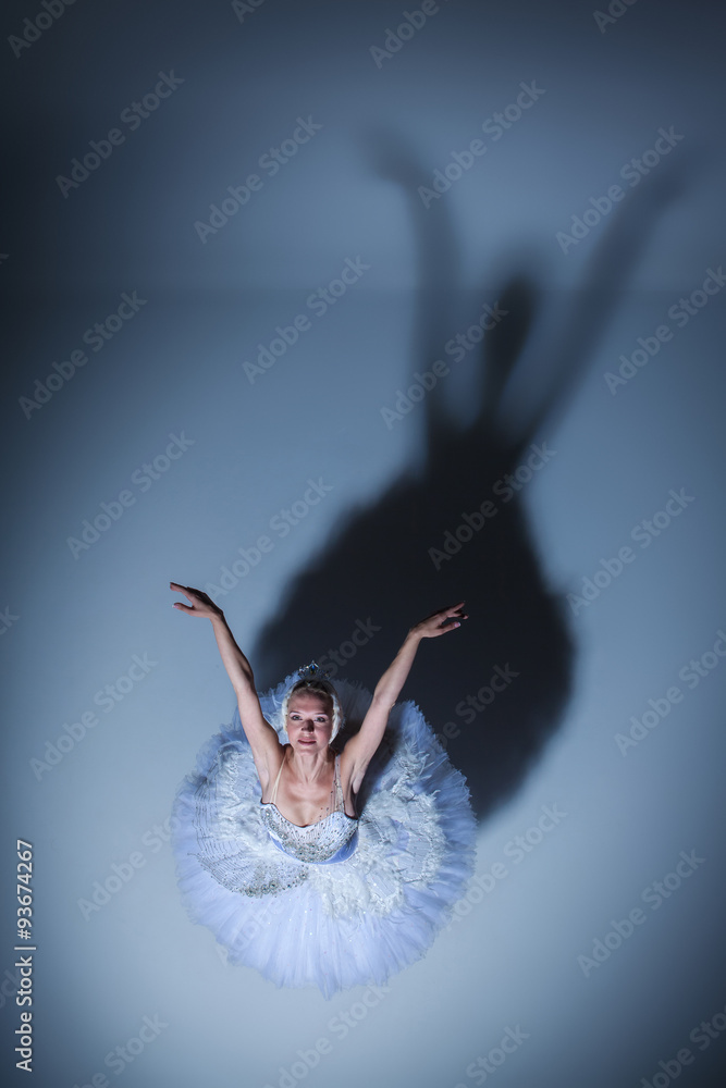 Fototapeta premium Portrait of the ballerina in ballet tatu on blue background