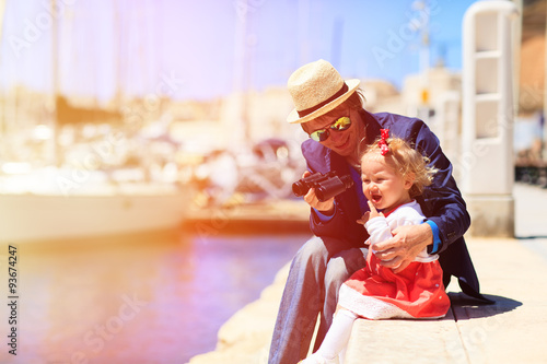father and little daughter looking at binoculars in the port