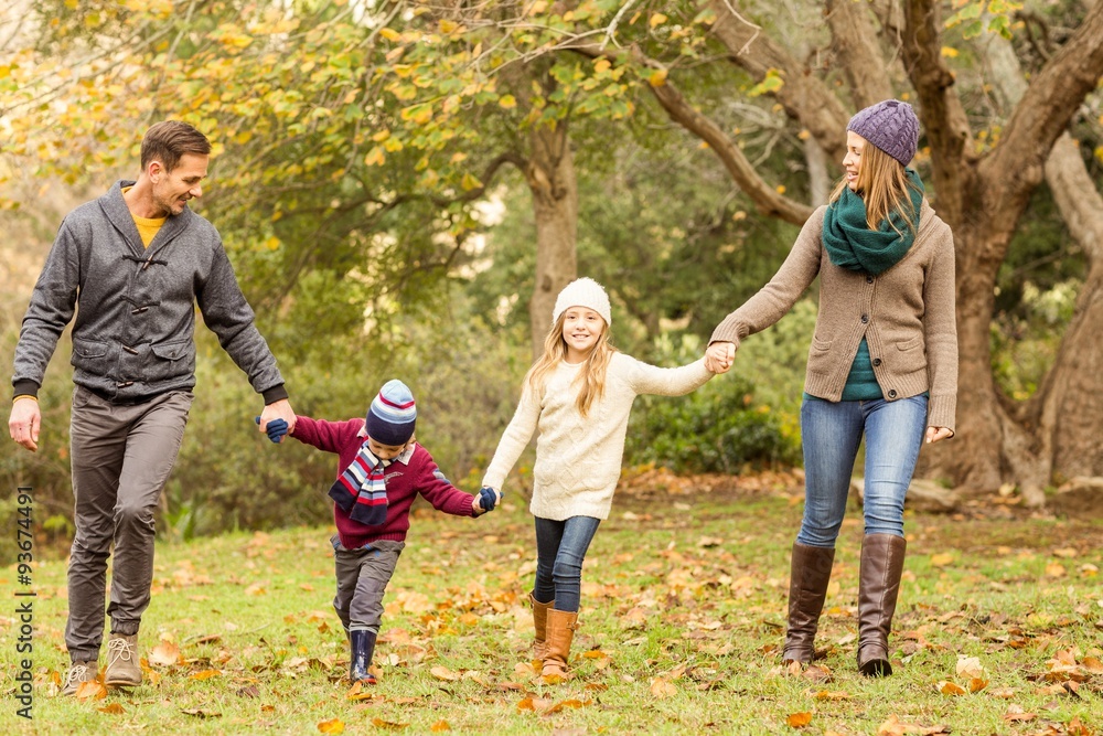 Fototapeta premium Smiling young family holding hands