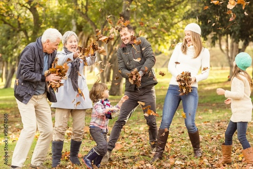 Happy extended family throwing leaves around photo