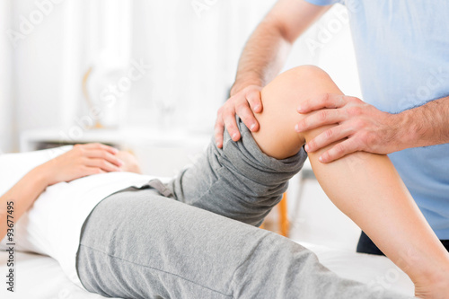 Young attractive woman being manipulated by physiotherapist photo