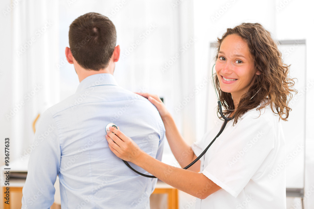 Young attractive doctor checking patient's heart beatment Young attractive doctor checking patient's heart beatment