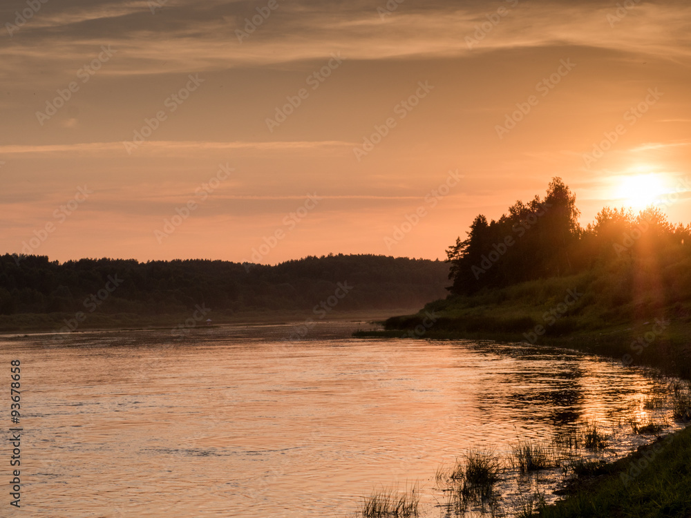 Fototapeta premium Foggy river with green grass in the sunlight