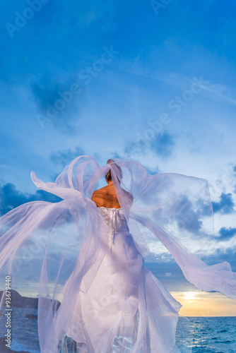 YOung bride by the sea at sunset