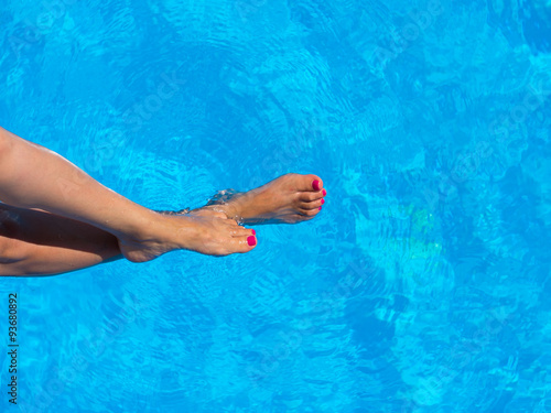 legs of woman lying near the pool . Beautiful female a foot