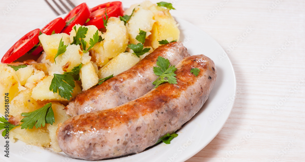 Potatoes with sausages on plate