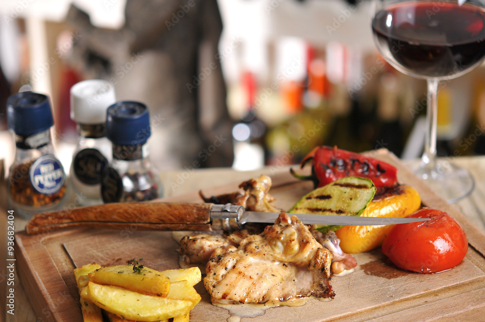 Chicken barbecue with fried potato and red wine on wood table Chicken barbecue with fried potato and red wine on wood table
