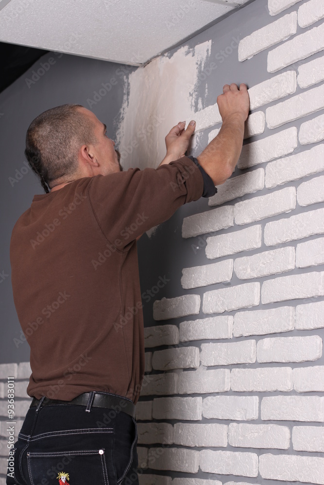 Builder applying tile on a wall Builder applying tile on a wall
