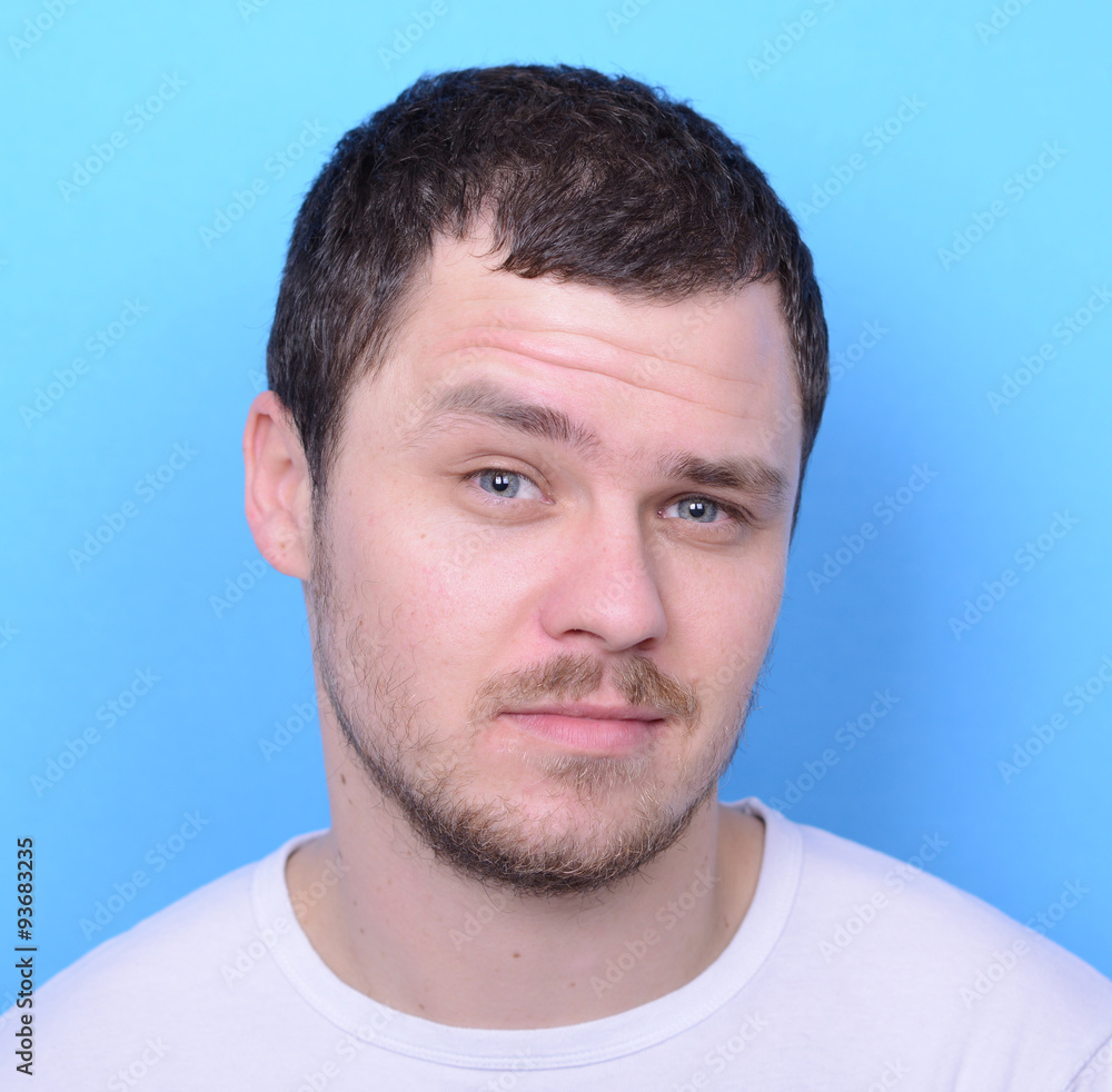 Fototapeta premium Portrait of handsome man in casual clothes against blue backgrou