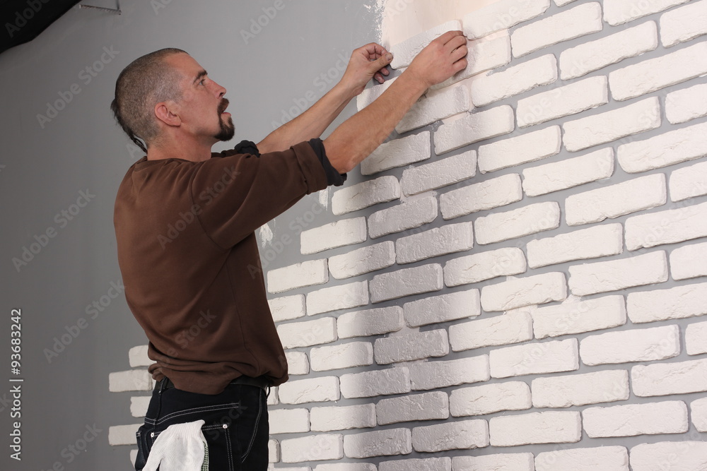 Builder applying tile on a wall Builder applying tile on a wall