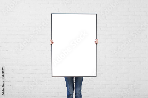 woman with blank poster on wall backgroundI photo